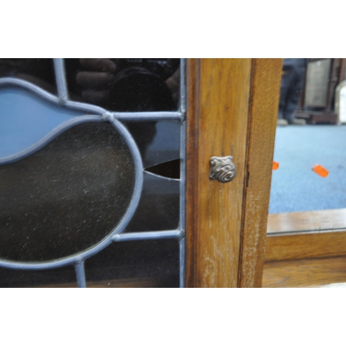 180 - A 20TH CENTURY OAK WALL HANGING SHELF, with two lead glazed doors, flanking a bevelled edge mirror, ... 