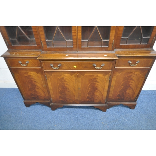 198 - A LATE 20TH CENTURY MAHOGANY BREAKFRONT BOOKCASE, fitted with four glazed doors, atop a base with th... 