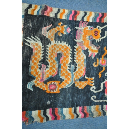 199 - A TIBETAN RECTANGULAR RUG, depicting two dragons, black field, and a multi-coloured border, 139cm x ... 