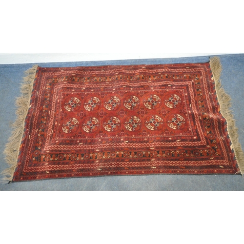 201 - A IRANIAN RED WOOLEN TEKKE RUG, with twelve central medallions, surrounded by a multi-strap border, ... 