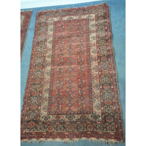 202 - TWO IRANIAN RED RUGS, both with repeating patterns, and a multi-strap border, largest 180cm x 106cm,... 