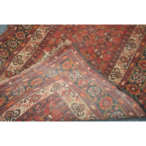 202 - TWO IRANIAN RED RUGS, both with repeating patterns, and a multi-strap border, largest 180cm x 106cm,... 