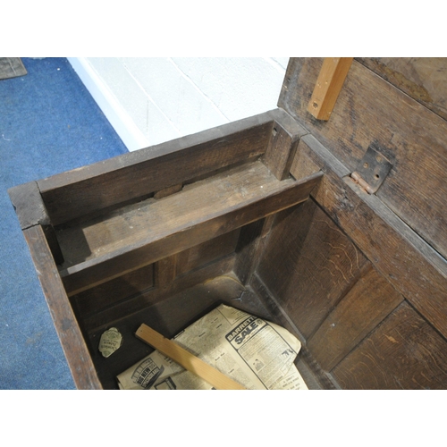 219 - A GEORGIAN OAK COFFER, the hinged lid enclosing a candle box, the front with repeating carvings, and... 