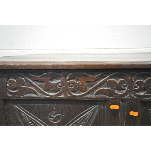 219 - A GEORGIAN OAK COFFER, the hinged lid enclosing a candle box, the front with repeating carvings, and... 