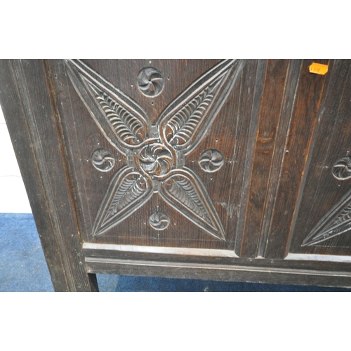 219 - A GEORGIAN OAK COFFER, the hinged lid enclosing a candle box, the front with repeating carvings, and... 