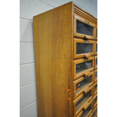 256 - A 20TH CENTURY OAK HABERDASHERY CABINET, fitted with sixteen glass fronted drawers, above a shelf, w... 