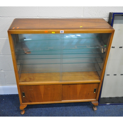 257 - A 20TH CENTURY WALNUT DISPLAY CABINET, the double glass sliding doors enclosing multiple glass shelv... 