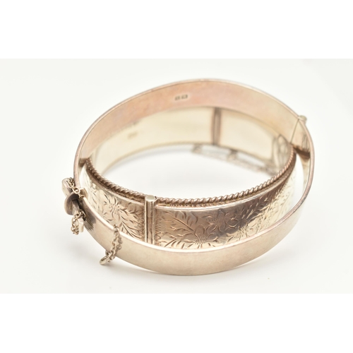 427 - TWO SILVER BANGLES, the first a hinged bangle with etched floral and rope detail, approximate width ... 