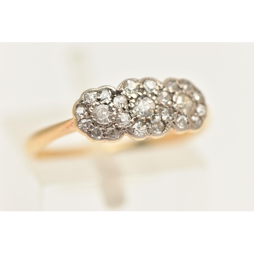 445 - A YELLOW METAL DIAMOND TRIPLE CLUSTER RING, designed as three flower clusters, each set with a singl... 