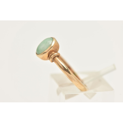 452 - A 9CT GOLD JADE RING, collet set with an oval cut green jade cabochon, to a polished band, hallmarke... 