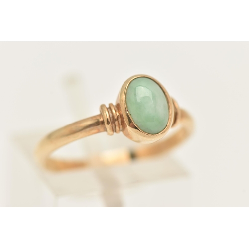 452 - A 9CT GOLD JADE RING, collet set with an oval cut green jade cabochon, to a polished band, hallmarke... 