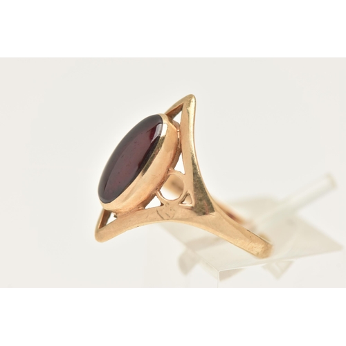 453 - A 9CT GOLD GARNET RING, collet set with an oval cut garnet, within an open work diamond shape mount ... 