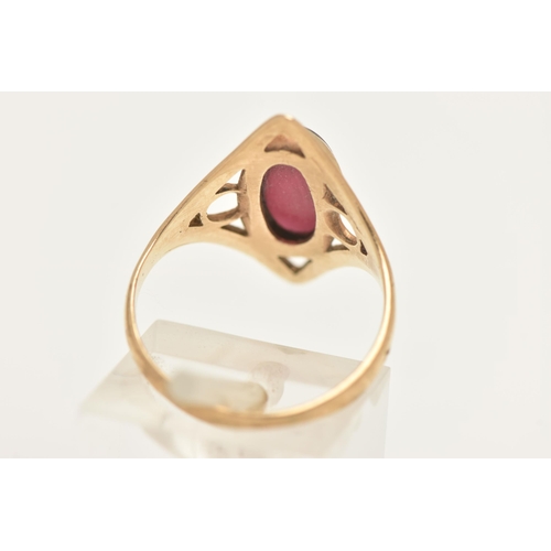 453 - A 9CT GOLD GARNET RING, collet set with an oval cut garnet, within an open work diamond shape mount ... 