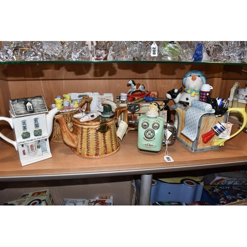 803 - A COLLECTION OF SEVEN NOVELTY TEAPOTS, comprising a Swineside Ceramics 'Teapottery' The Acme Steam B... 