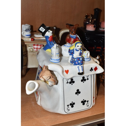 810 - EIGHT NOVELTY TEAPOTS, comprising a South-West Ceramics Ltd Alice in Wonderland themed teapot (two s... 