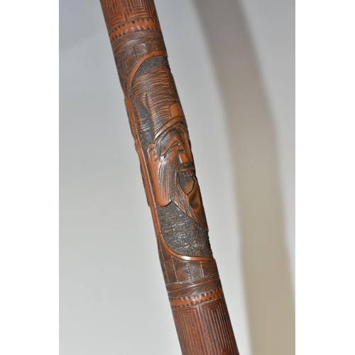 831 - A JAPANESE MEIJI PERIOD SAMURAI CARVED BAMBOO WALKING STICK carved in relief with five carved faces ... 