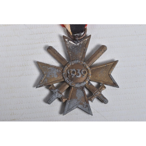 223 - A GERMAN WWII ERA WAR MERIT CROSS WITH SWORDS AND A BLACK WAND BADGE, the Merit Cross comes with a r... 