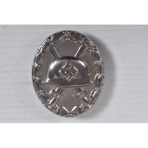 228 - A GERMAN SILVER WOUND BADGE WITH MAKER MARK L21, it has a vertical pin and the award has a solid bac... 