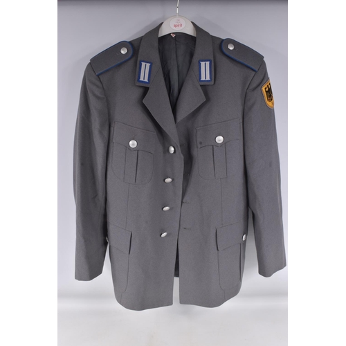 283 - TWO EAST GERMANY MILITARY JACKETS FOR OFFICERS, both are grey in colour with one having a red piping... 