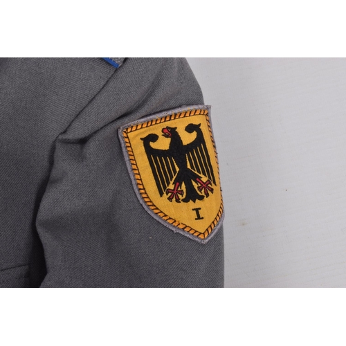 283 - TWO EAST GERMANY MILITARY JACKETS FOR OFFICERS, both are grey in colour with one having a red piping... 