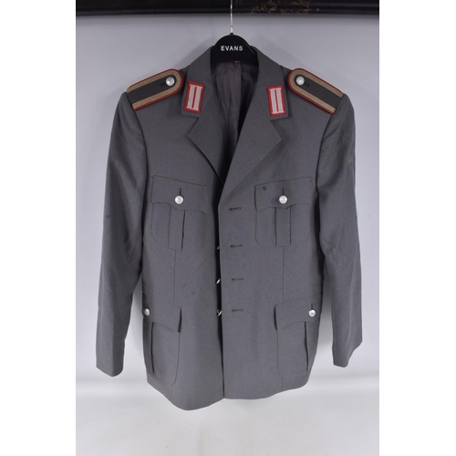 283 - TWO EAST GERMANY MILITARY JACKETS FOR OFFICERS, both are grey in colour with one having a red piping... 