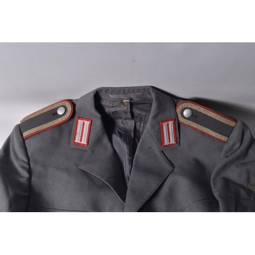 283 - TWO EAST GERMANY MILITARY JACKETS FOR OFFICERS, both are grey in colour with one having a red piping... 