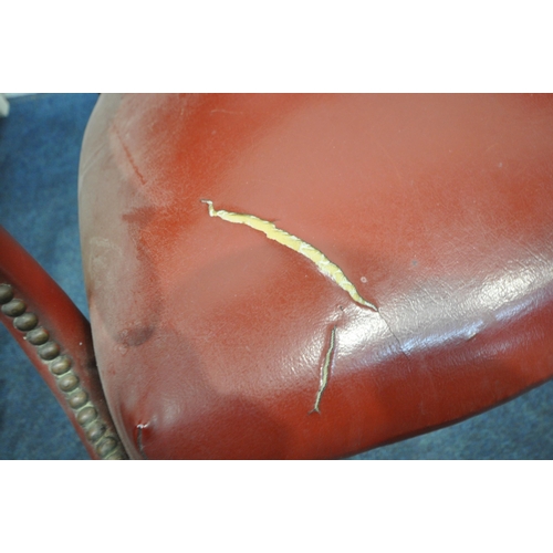 151 - A HARLEQUIN SET OF FOUR RED LEATHERETTE ARMCHAIRS, with a curved backrest, open armrests with brass ... 