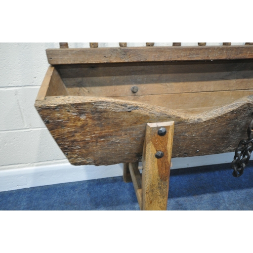 152 - A CATTLE TROUGH, with various alterations and timbers, later legs, with a cattle guard, length 202cm... 