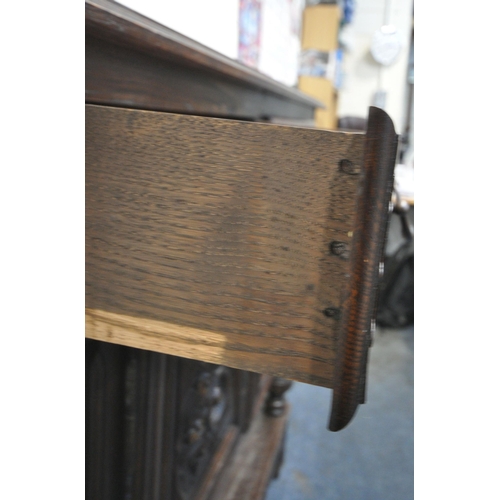 155 - AN EARLY 20TH CENTURY OAK BUFFET, fitted with two drawers, over double cupboard doors, raised on tur... 