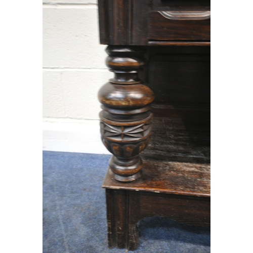 155 - AN EARLY 20TH CENTURY OAK BUFFET, fitted with two drawers, over double cupboard doors, raised on tur... 