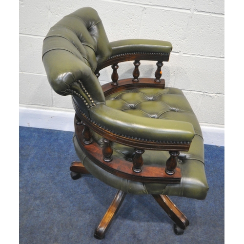 185 - A 20TH CENTURY GREEN BUTTONED LEATHER SWIVEL OFFICE CHAIR, with a bow top, shaped armrests, raised o... 