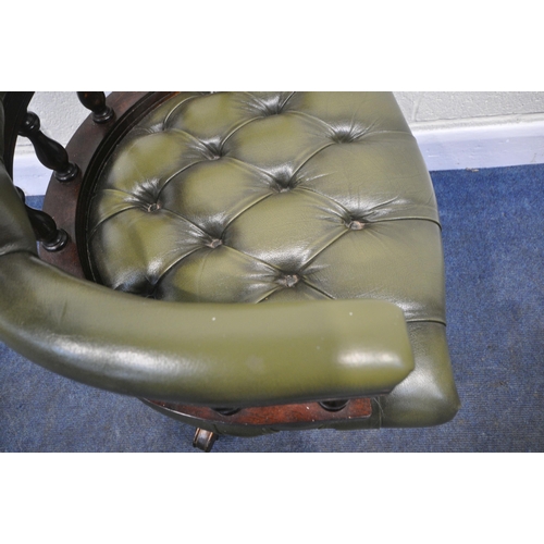 185 - A 20TH CENTURY GREEN BUTTONED LEATHER SWIVEL OFFICE CHAIR, with a bow top, shaped armrests, raised o... 