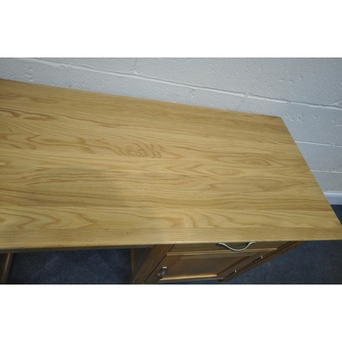 191 - A MODERN OAK DESK, fitted with a slim door, a pull out slide, a single drawer, above a door, width 1... 