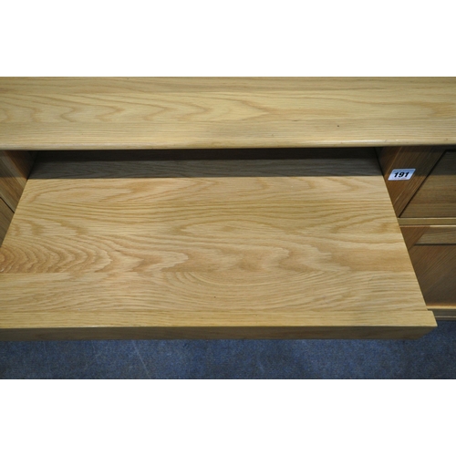 191 - A MODERN OAK DESK, fitted with a slim door, a pull out slide, a single drawer, above a door, width 1... 