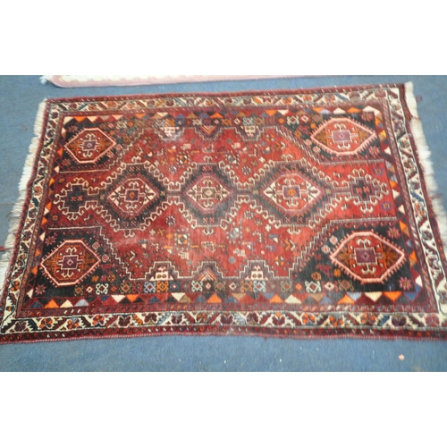 222 - A RED GROUND SHIRAZ RUG, with repeating geometric patterns, united by a multi-strap border, 173cm x ... 