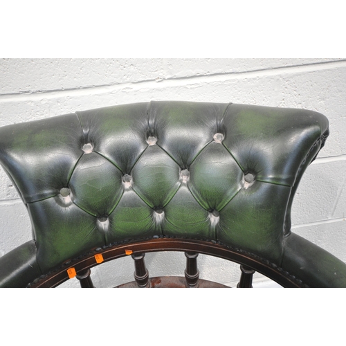 232 - A 20TH CENTURY GREEN BUTTONED LEATHER SWIVEL OFFICE CHAIR, with a bow top, shaped armrests, raised o... 