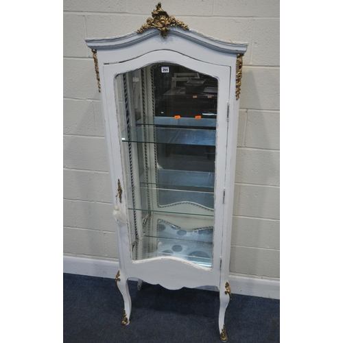 264 - A WHITE PAINTED CHINA CABINET, the arched top with gold a painted crest, the single door enclosing a... 