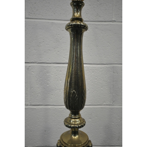 267 - A 20TH CENTURY BRASS STANDARD LAMP, with a foliate pillar, triple rams head, three scrolled supports... 