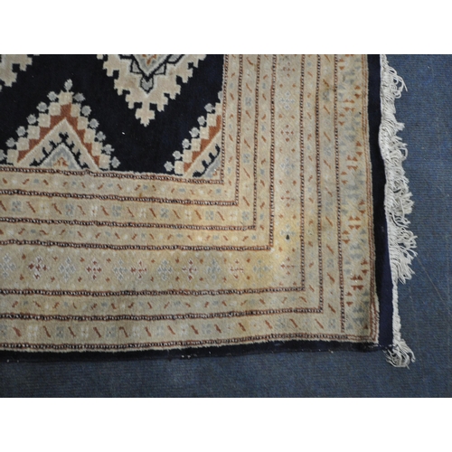 280 - A BLUE GROUND HAND MADE PAKISTANI RECTANGULAR RUG, with repeating geometric patterns, surrounded by ... 