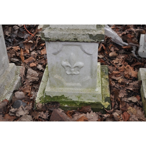 33 - A PAIR OF COMPOSITE GARDEN URNS ON STANDS, with fluted balustered bowls and Fleur de Lys detail to b... 