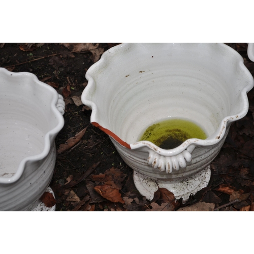 9 - A SET OF THREE WHITE GLAZED TERRACOTTA PLANT POTS with waved rims and two handles to each (one rim d... 