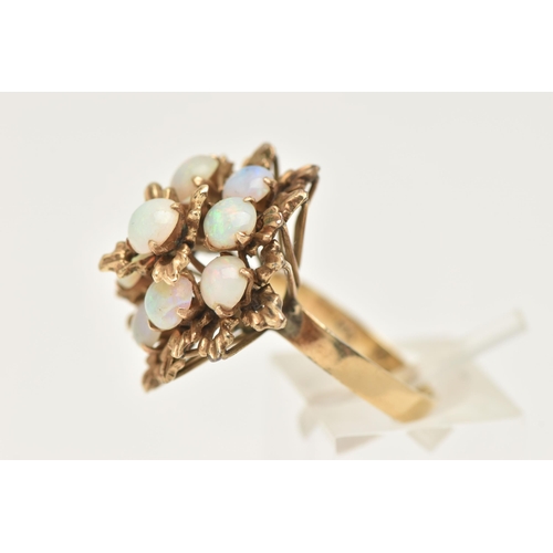 420 - A YELLOW METAL OPAL SET CLUSTER RING, large floral design set with nine circular cut white opal cabo... 