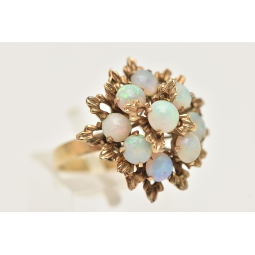 420 - A YELLOW METAL OPAL SET CLUSTER RING, large floral design set with nine circular cut white opal cabo... 