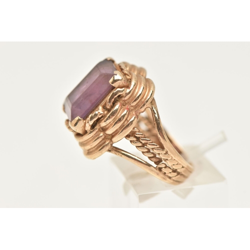 426 - A 9CT GOLD AMETHYST RING, set with a rectangular cut amethyst, four claw set to a stepped scallop su... 