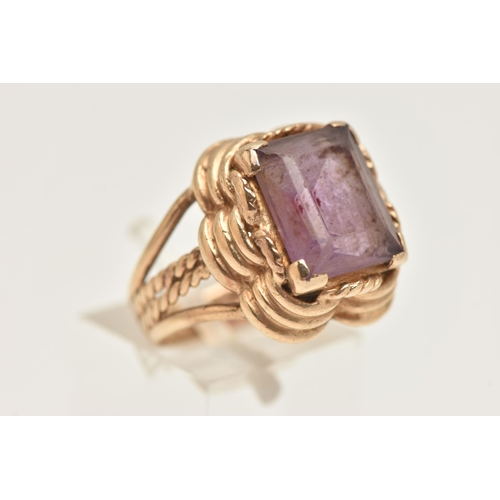 426 - A 9CT GOLD AMETHYST RING, set with a rectangular cut amethyst, four claw set to a stepped scallop su... 