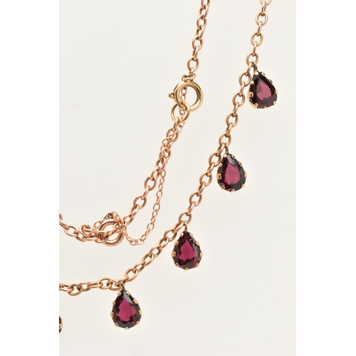 452 - A ROSE METAL GARNET NECKLACE, cable chain fitted with eight pear cut garnet droppers, each in a claw... 