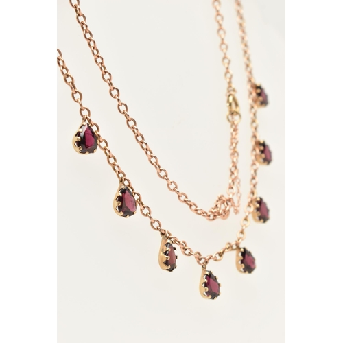 452 - A ROSE METAL GARNET NECKLACE, cable chain fitted with eight pear cut garnet droppers, each in a claw... 