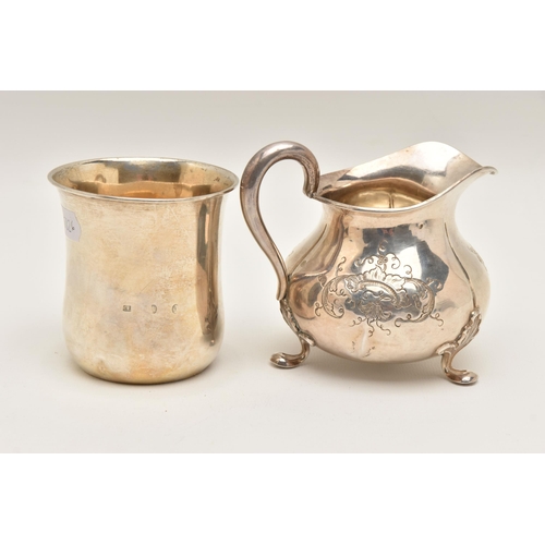 483 - TWO WHITE METAL ITEMS, to include a cream jug with engraved floral pattern, raised on three leaf det... 