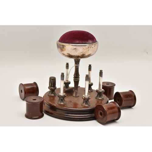 490 - AN EARLY 20TH CENTURY THREAD HOLDER AND PIN CUSHION, a wooden circular base with five thread / spool... 