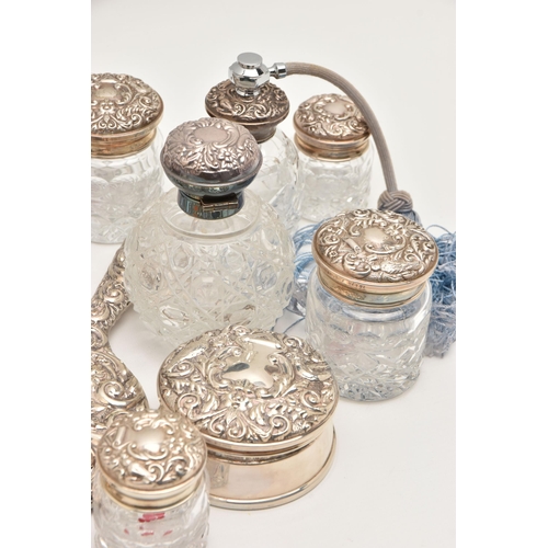 512 - A BOX OF ASSORTED SILVER VANITY ITEMS, to include six glass jars with silver lids, a glass bottle wi... 